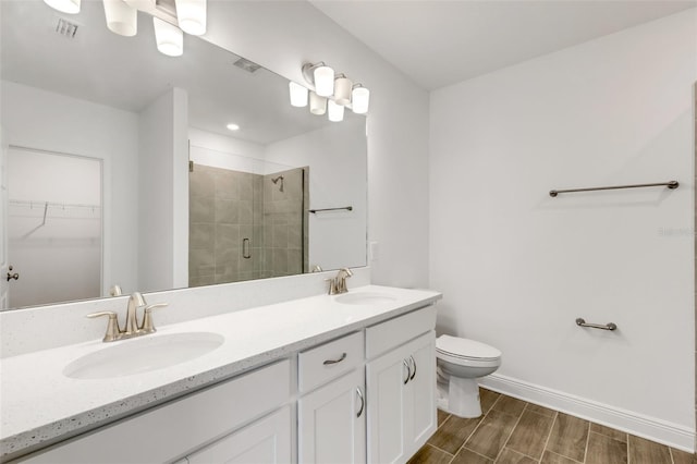5213 Patano Loop, Palmetto, FL 34221 - full bath featuring a stall shower, double vanity, toilet, a walk in closet, and wood tiled floors
