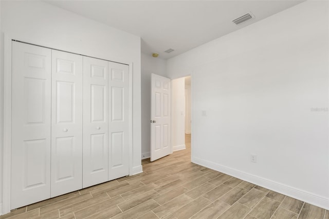 5213 Patano Loop, Palmetto, FL 34221 - unfurnished bedroom with light wood finished floors, baseboards, and a closet