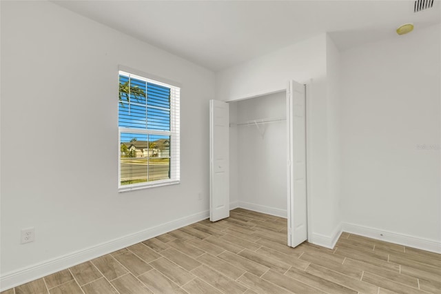 5213 Patano Loop, Palmetto, FL 34221 - unfurnished bedroom with light wood finished floors, baseboards, and a closet