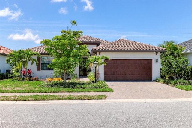 8020 Clearwater Ct, Sarasota, FL 34241 - mediterranean / spanish home with an attached garage, driveway, a tile roof, and stucco siding