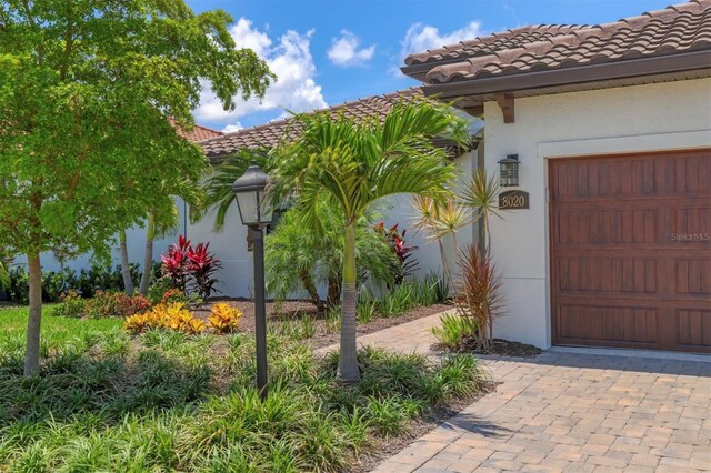 8020 Clearwater Ct, Sarasota, FL 34241 - view of exterior entry featuring a tile roof and stucco siding