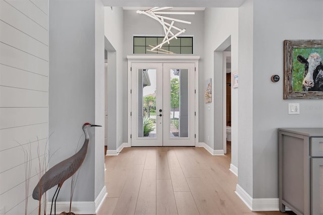 8020 Clearwater Ct, Sarasota, FL 34241 - entrance foyer with french doors, wood finished floors, baseboards, and a chandelier