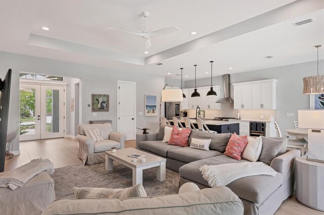 8020 Clearwater Ct, Sarasota, FL 34241 - living room featuring beverage cooler, a tray ceiling, light wood finished floors, ceiling fan, and recessed lighting