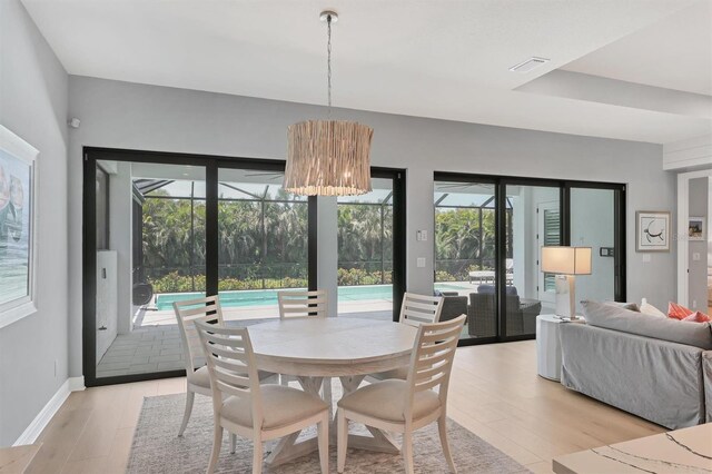 8020 Clearwater Ct, Sarasota, FL 34241 - dining area featuring light wood-style flooring, a chandelier, and baseboards
