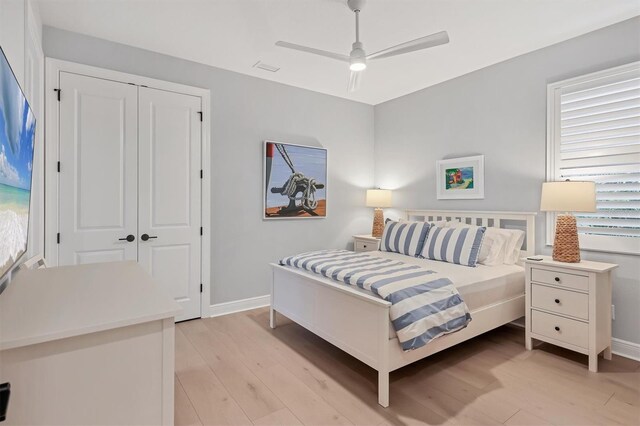 8020 Clearwater Ct, Sarasota, FL 34241 - bedroom with light wood-style flooring, baseboards, ceiling fan, and a closet