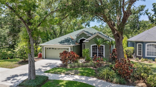 135 Tall Trees Ct, Sarasota, FL 34232 - view of front of house featuring an attached garage, stucco siding, driveway, and roof with shingles