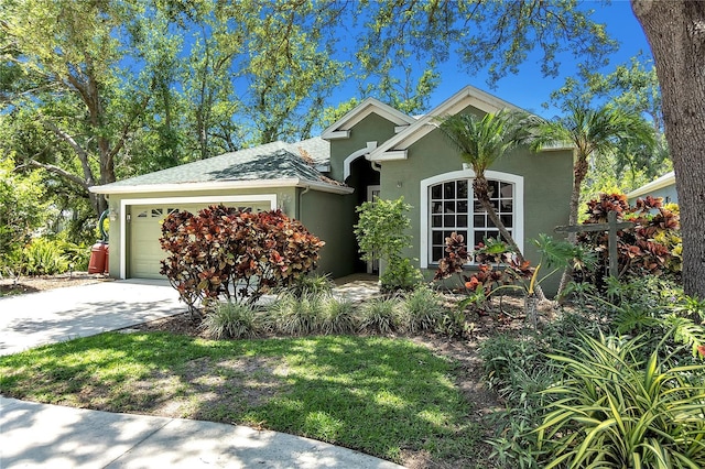 135 Tall Trees Ct, Sarasota, FL 34232 - view of front facade with stucco siding, an attached garage, and driveway