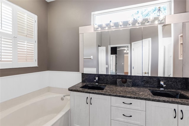 135 Tall Trees Ct, Sarasota, FL 34232 - full bathroom featuring double vanity, a garden tub, and wainscoting
