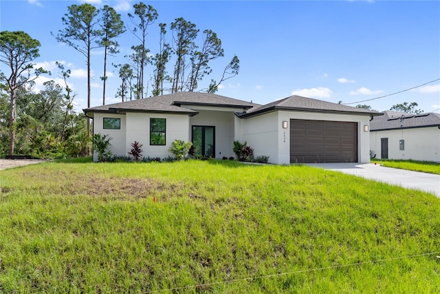 2638 Hagerick Ln, North Port, FL 34288 - prairie-style home with an attached garage, stucco siding, driveway, and a front yard