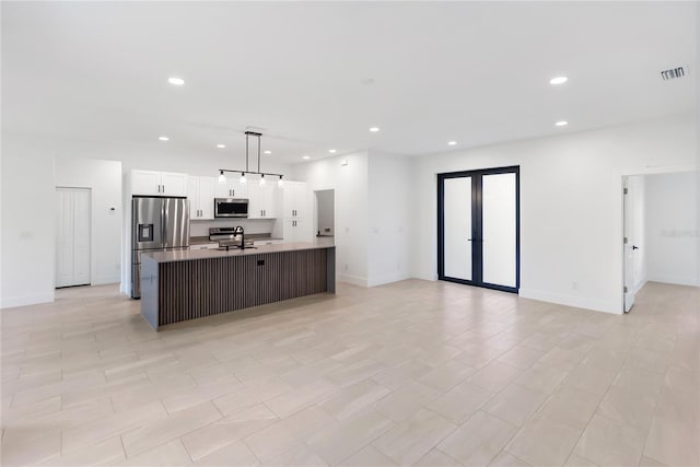 2638 Hagerick Ln, North Port, FL 34288 - kitchen with stainless steel appliances, a kitchen island with sink, recessed lighting, white cabinetry, and open floor plan