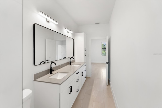 2638 Hagerick Ln, North Port, FL 34288 - full bathroom with double vanity, toilet, baseboards, and tile patterned floors