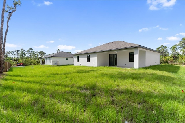 2638 Hagerick Ln, North Port, FL 34288 - back of house with a ceiling fan, stucco siding, and a lawn