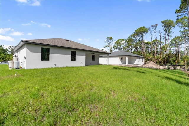 2638 Hagerick Ln, North Port, FL 34288 - back of property featuring stucco siding and a lawn
