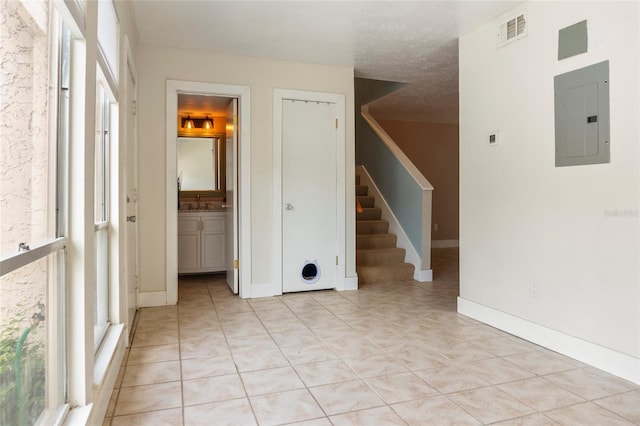 4475 Sandner Dr, Sarasota, FL 34243 - spare room featuring electric panel, stairs, and light tile patterned floors