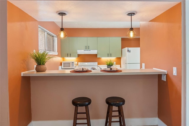 4475 Sandner Dr, Sarasota, FL 34243 - kitchen with white appliances, under cabinet range hood, a peninsula, pendant lighting, and a breakfast bar area