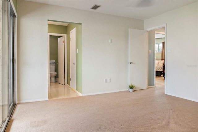 4475 Sandner Dr, Sarasota, FL 34243 - unfurnished bedroom featuring light carpet, ensuite bath, and baseboards