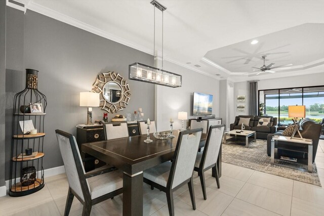 12856 Sorrento Way, Bradenton, FL 34211 - dining space with ornamental molding, light tile patterned floors, a raised ceiling, ceiling fan, and baseboards