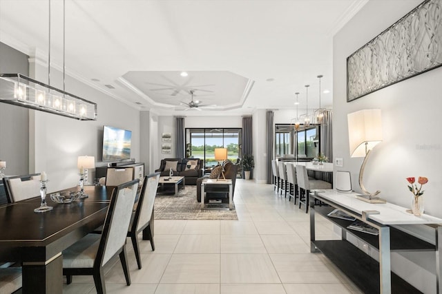 12856 Sorrento Way, Bradenton, FL 34211 - dining space with a ceiling fan, light tile patterned flooring, a tray ceiling, a chandelier, and ornamental molding