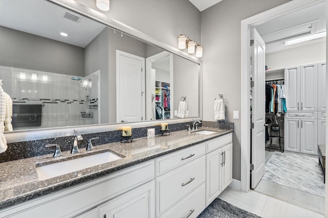 12856 Sorrento Way, Bradenton, FL 34211 - bathroom featuring double vanity, a walk in closet, tiled shower, and tile patterned floors