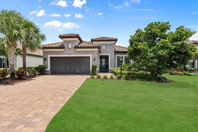 12856 Sorrento Way, Bradenton, FL 34211 - mediterranean / spanish-style house with an attached garage, decorative driveway, a front lawn, a tile roof, and stucco siding