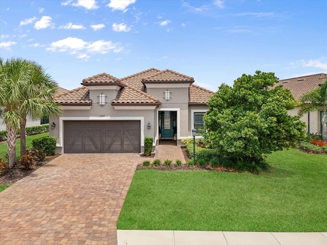 12856 Sorrento Way, Bradenton, FL 34211 - mediterranean / spanish home featuring a tile roof, an attached garage, stucco siding, a front yard, and decorative driveway