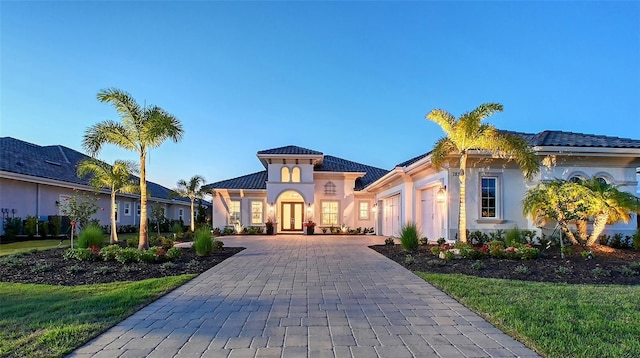7838 Bowspirit Way, Lakewood Ranch, FL 34202 - mediterranean / spanish-style house with an attached garage, french doors, decorative driveway, a tiled roof, and stucco siding