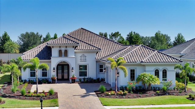 7838 Bowspirit Way, Lakewood Ranch, FL 34202 - mediterranean / spanish home with french doors, a tile roof, stucco siding, and decorative driveway