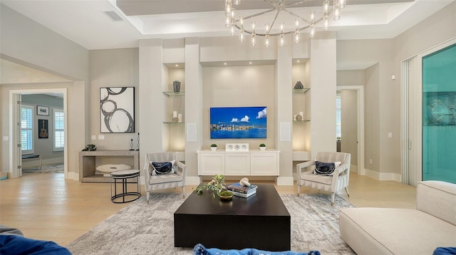 7838 Bowspirit Way, Lakewood Ranch, FL 34202 - living room featuring light wood finished floors, built in features, baseboards, and a chandelier