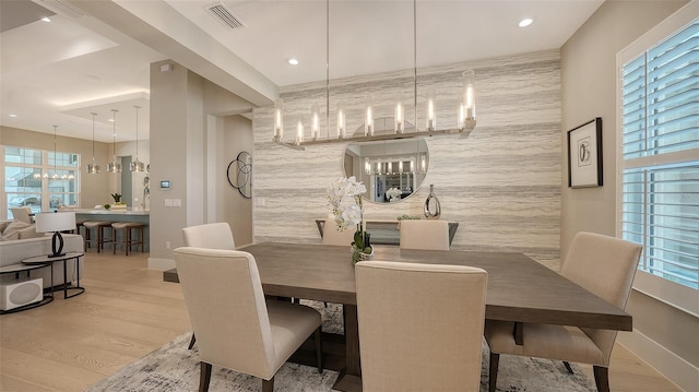 7838 Bowspirit Way, Lakewood Ranch, FL 34202 - dining room with a chandelier, baseboards, wood finished floors, an accent wall, and recessed lighting