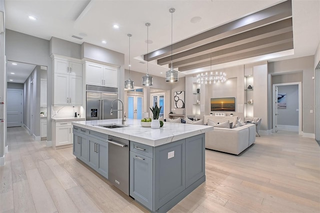 7838 Bowspirit Way, Lakewood Ranch, FL 34202 - kitchen featuring a sink, stainless steel appliances, white cabinets, and light wood-style flooring