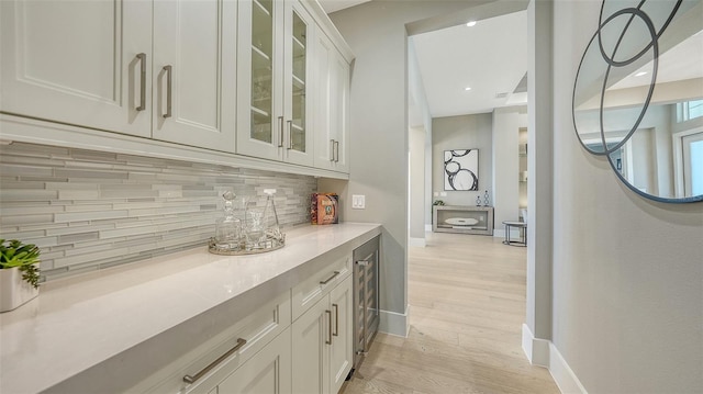 7838 Bowspirit Way, Lakewood Ranch, FL 34202 - indoor dry bar featuring beverage cooler, decorative backsplash, light wood finished floors, and baseboards