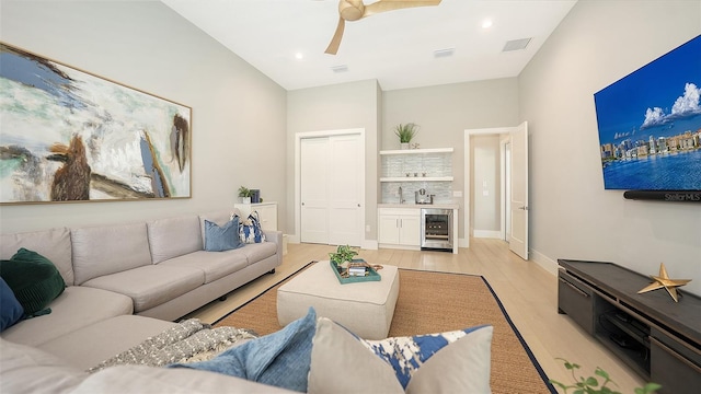 7838 Bowspirit Way, Lakewood Ranch, FL 34202 - living room with bar, beverage cooler, light wood-style flooring, a ceiling fan, and baseboards
