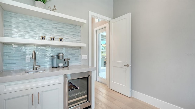 7838 Bowspirit Way, Lakewood Ranch, FL 34202 - indoor wet bar featuring wine cooler, backsplash, light wood-style floors, and baseboards