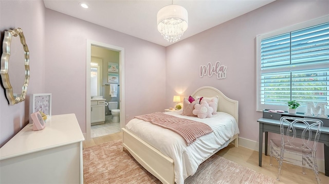 7838 Bowspirit Way, Lakewood Ranch, FL 34202 - bedroom featuring a chandelier, ensuite bathroom, light wood-style floors, and baseboards