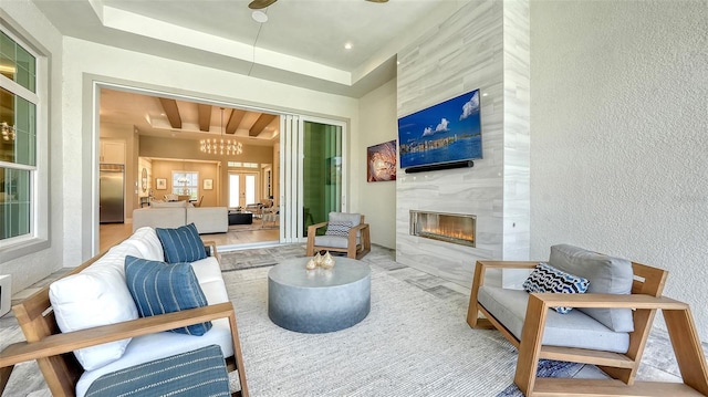 7838 Bowspirit Way, Lakewood Ranch, FL 34202 - living room featuring a textured wall, a high end fireplace, a chandelier, and a tray ceiling