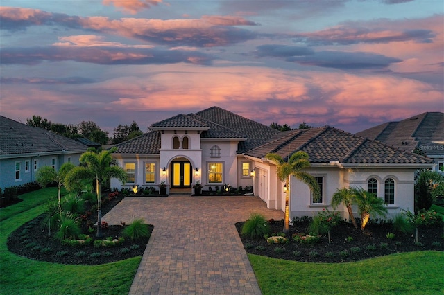 7838 Bowspirit Way, Lakewood Ranch, FL 34202 - mediterranean / spanish-style house featuring decorative driveway, a garage, stucco siding, and a lawn