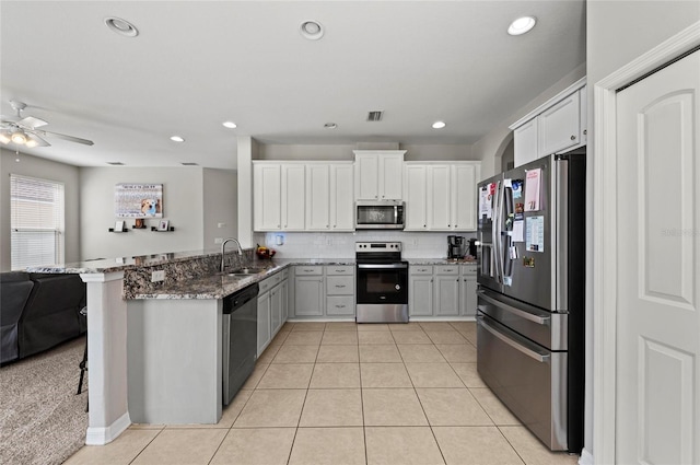 5224 58th Ter E, Bradenton, FL 34203 - kitchen featuring appliances with stainless steel finishes, open floor plan, stone counters, a ceiling fan, and a peninsula