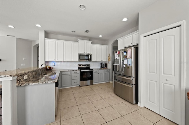 5224 58th Ter E, Bradenton, FL 34203 - kitchen featuring stainless steel appliances, a sink, a peninsula, arched walkways, and tasteful backsplash