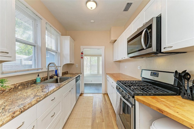 2509 8th Ave W, Bradenton, FL 34205 - kitchen featuring stainless steel appliances, a sink, wood counters, white cabinetry, and light wood finished floors