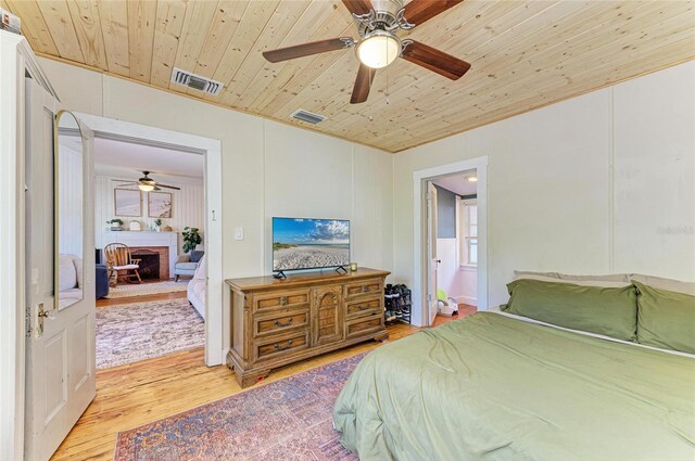 2509 8th Ave W, Bradenton, FL 34205 - bedroom with light wood-style floors, wooden ceiling, a brick fireplace, and a ceiling fan