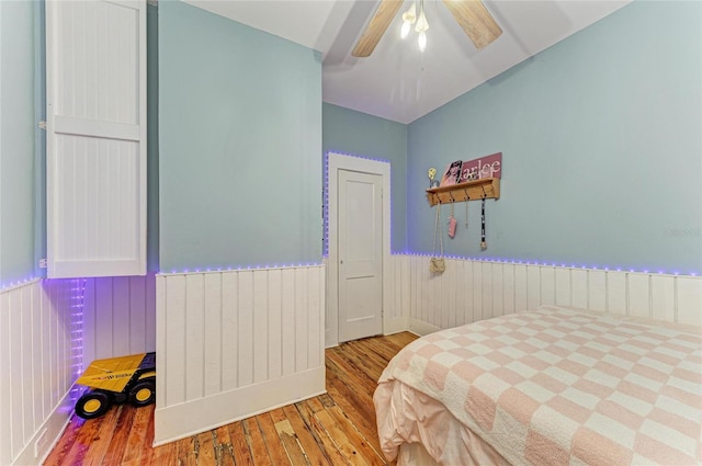 2509 8th Ave W, Bradenton, FL 34205 - bedroom with wood finished floors, a wainscoted wall, a ceiling fan, and wooden walls