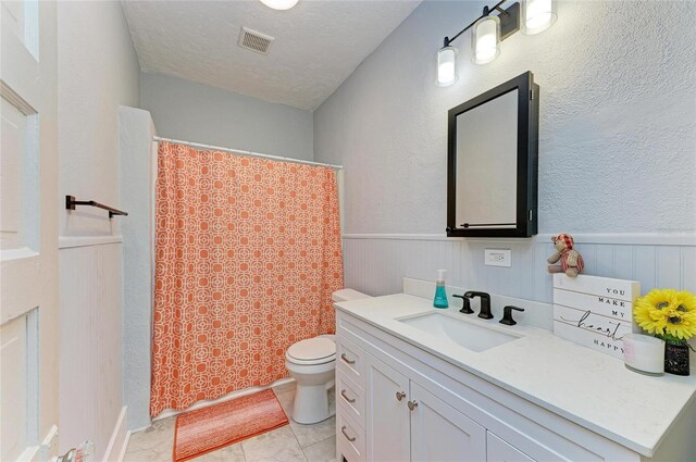 2509 8th Ave W, Bradenton, FL 34205 - bathroom featuring vanity, toilet, a textured ceiling, wainscoting, and curtained shower