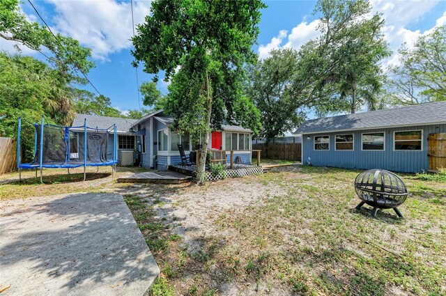 2509 8th Ave W, Bradenton, FL 34205 - view of yard featuring an outdoor fire pit, a trampoline, and a deck