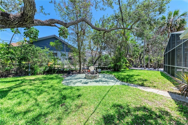 5223 Shadow Lawn Dr, Sarasota, FL 34242 - view of grassy yard with a patio area, an outdoor fire pit, and a lanai