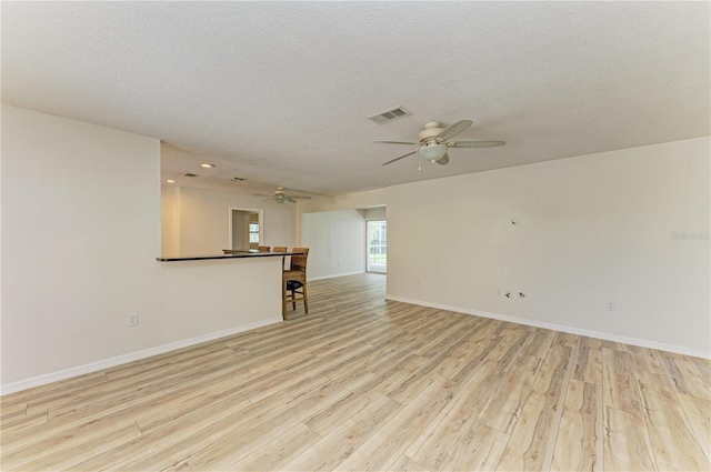5223 Shadow Lawn Dr, Sarasota, FL 34242 - empty room with a ceiling fan, light wood-style flooring, baseboards, and a textured ceiling