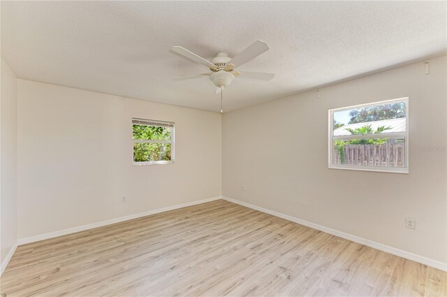 5223 Shadow Lawn Dr, Sarasota, FL 34242 - empty room with light wood-type flooring, baseboards, ceiling fan, and a textured ceiling