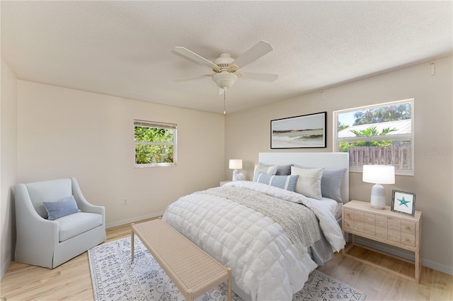 5223 Shadow Lawn Dr, Sarasota, FL 34242 - bedroom featuring light wood finished floors, baseboards, a ceiling fan, and a textured ceiling