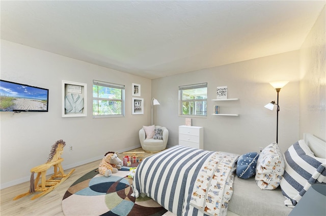 5223 Shadow Lawn Dr, Sarasota, FL 34242 - bedroom featuring multiple windows, wood finished floors, and baseboards