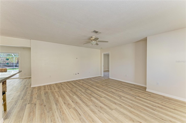 5223 Shadow Lawn Dr, Sarasota, FL 34242 - unfurnished room featuring light wood finished floors, a textured ceiling, ceiling fan, and baseboards