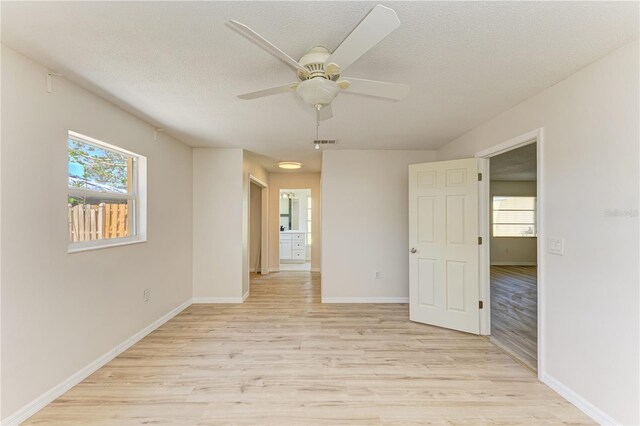 5223 Shadow Lawn Dr, Sarasota, FL 34242 - empty room with light wood-style floors, ceiling fan, baseboards, and a textured ceiling